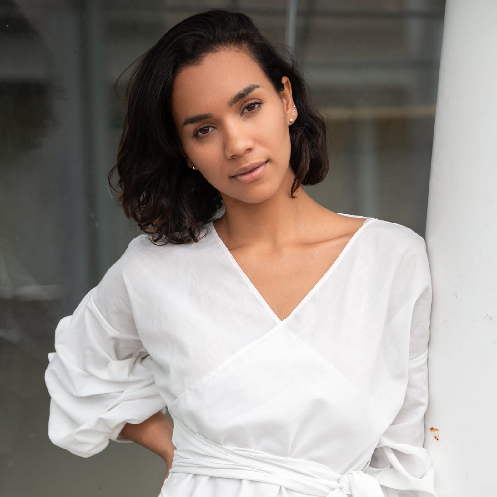 Woman with dark, short hair wearing a white dress