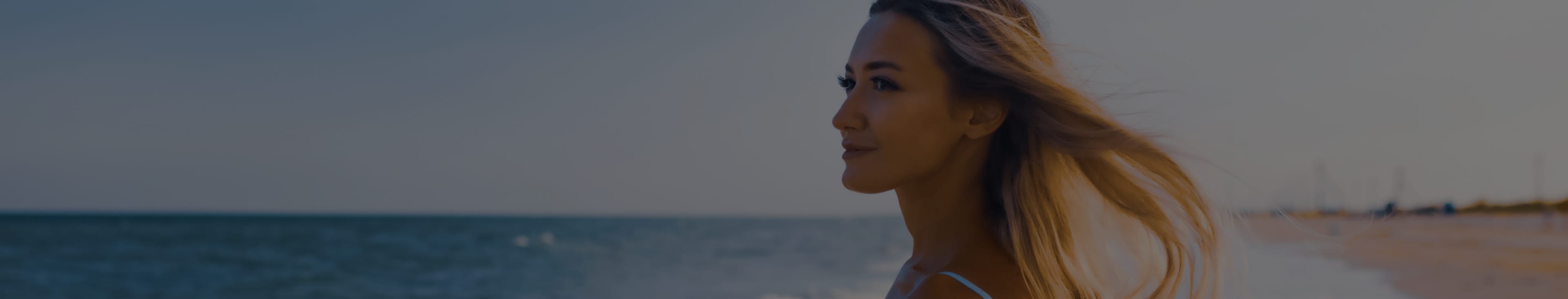 Beautiful blonde woman looking out at the ocean