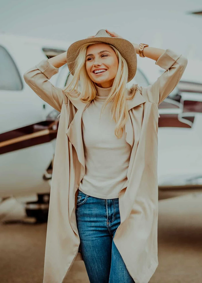 Smiling woman walking away from an airplane.