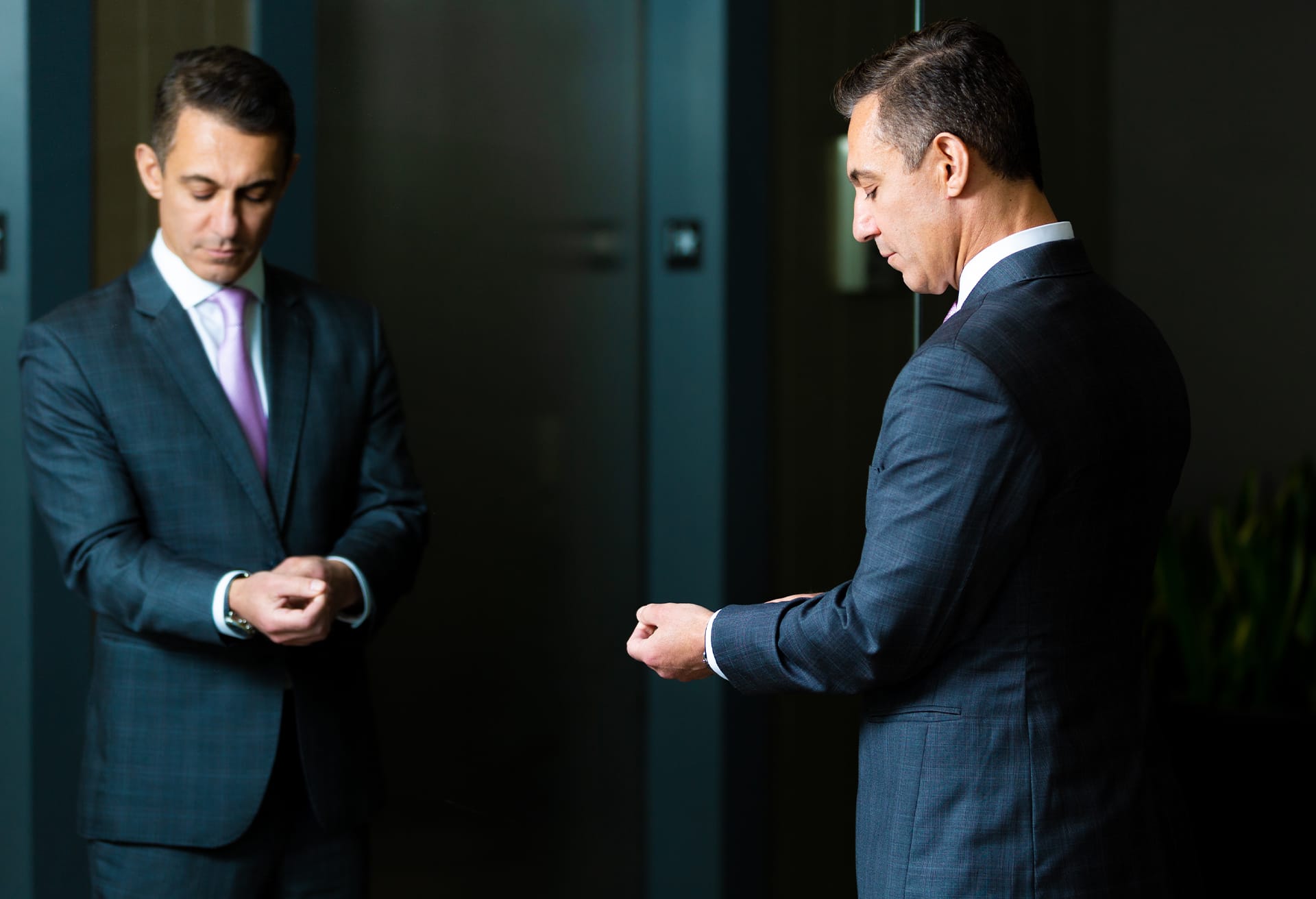 Dr. Tirgari fixing his sleeves in a mirror