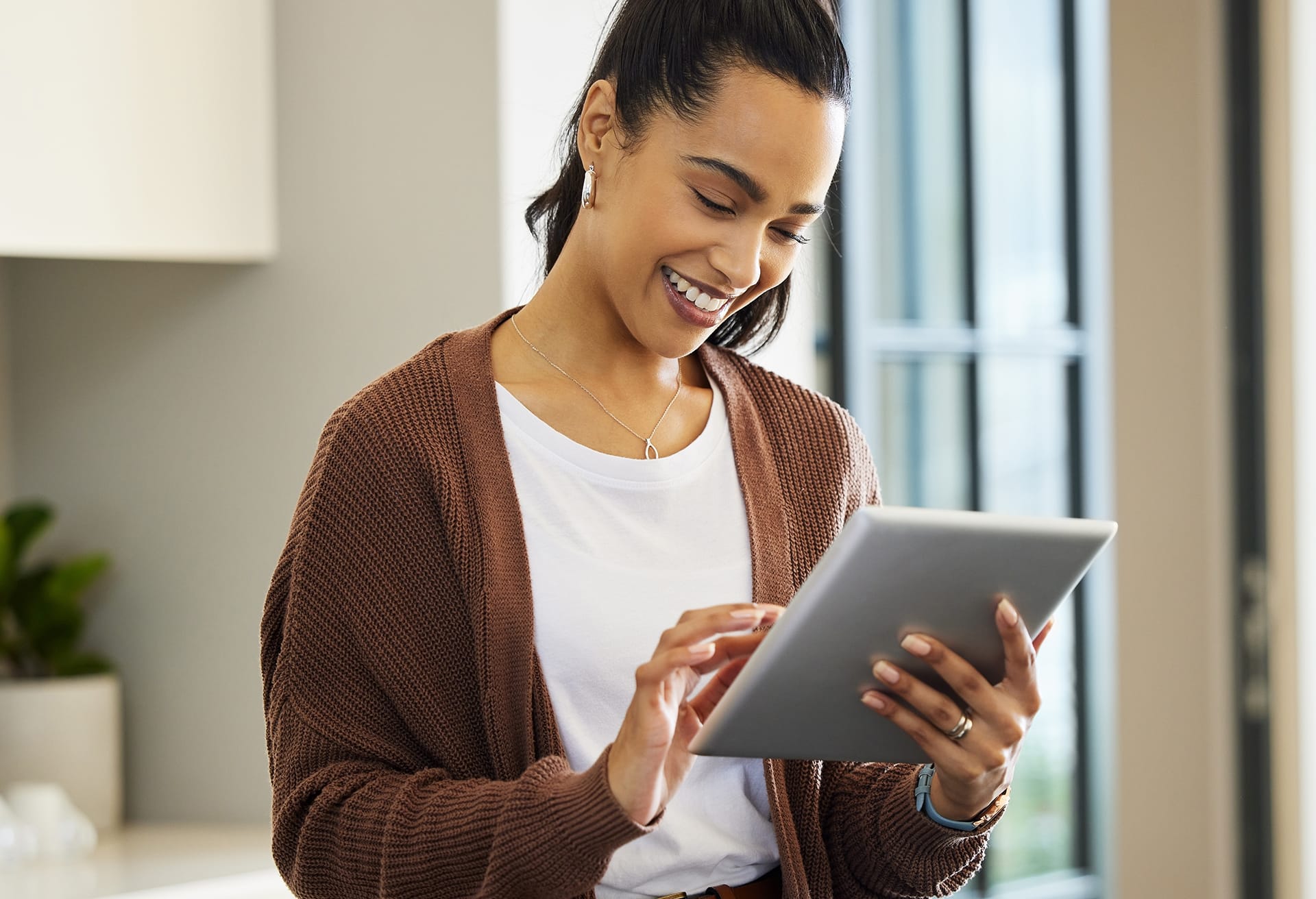 Woman with a pony tail using a silver tablet