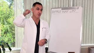 A man in a lab coat stands next to a blank whiteboard, gesturing while speaking