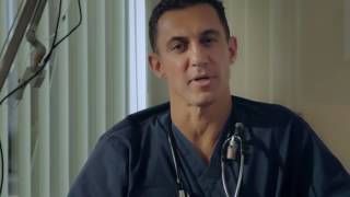 A person in medical scrubs speaks directly to the camera