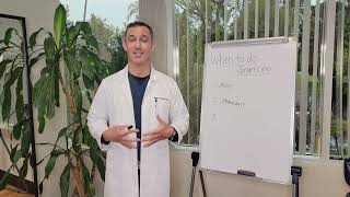 A person in a lab coat stands next to a whiteboard with notes