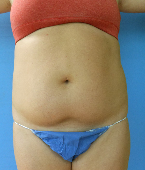 Bare midriff of a person wearing a red sports bra and blue underwear against a blue background