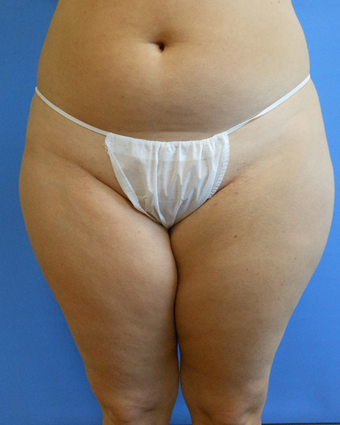 Person wearing a white sheer thong, standing against a blue background