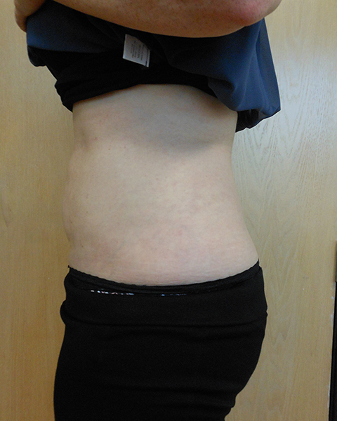 A side view of a person’s midsection, wearing a dark top and black pants